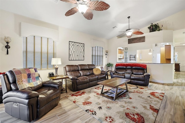 living room featuring light hardwood / wood-style flooring, ceiling fan, and vaulted ceiling