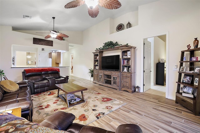 living room with ceiling fan, lofted ceiling, and light hardwood / wood-style flooring