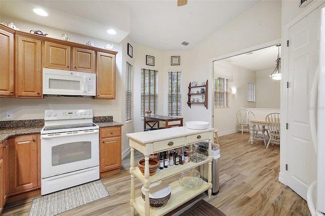 kitchen with hanging light fixtures, lofted ceiling, light wood-type flooring, and white appliances