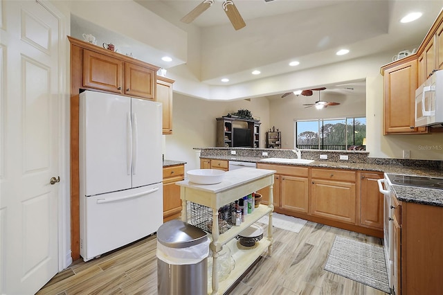 kitchen featuring sink, ceiling fan, kitchen peninsula, white appliances, and light hardwood / wood-style flooring