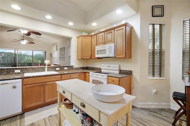 kitchen with lofted ceiling, sink, white appliances, and light hardwood / wood-style floors