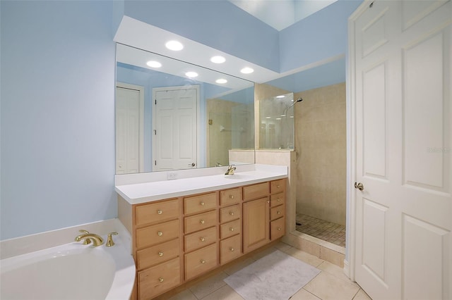 bathroom featuring tile patterned floors, vanity, and a tile shower