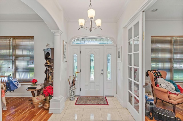 foyer entrance featuring plenty of natural light, light hardwood / wood-style flooring, and crown molding