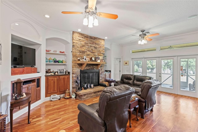 living room with a fireplace, ceiling fan, hardwood / wood-style flooring, and built in features