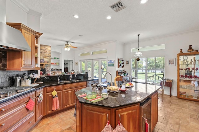 kitchen with a wealth of natural light, a textured ceiling, a center island, and light tile patterned floors