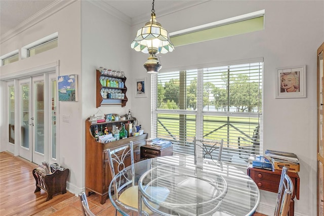 dining room featuring light hardwood / wood-style floors, crown molding, and french doors