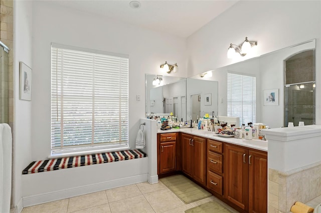 bathroom with tile patterned flooring, a shower with door, vanity, and a healthy amount of sunlight