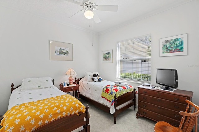 bedroom featuring ceiling fan, crown molding, and light colored carpet