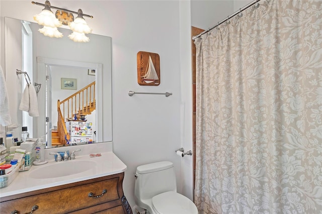 bathroom with toilet, vanity, and curtained shower