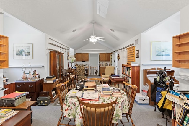 dining room with ceiling fan, carpet flooring, and lofted ceiling