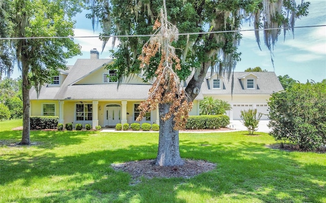 view of front of house featuring covered porch, a garage, and a front yard