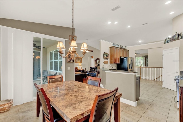 dining space featuring light tile patterned floors, an inviting chandelier, and vaulted ceiling