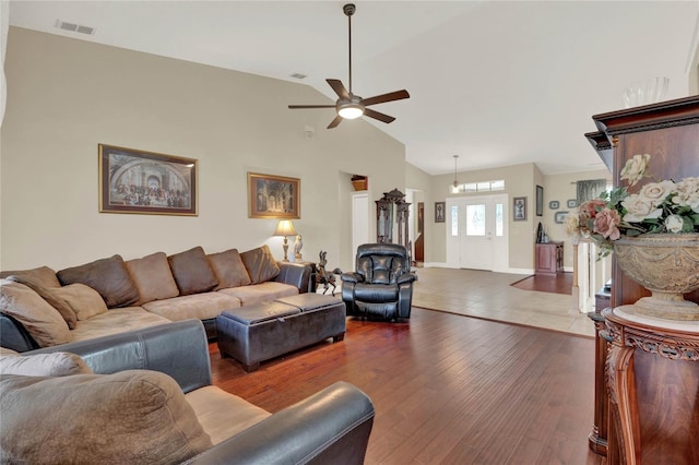 living room with ceiling fan, dark hardwood / wood-style floors, and lofted ceiling