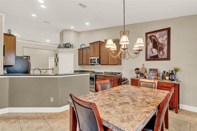 kitchen featuring stainless steel appliances, light tile patterned flooring, hanging light fixtures, a chandelier, and a center island