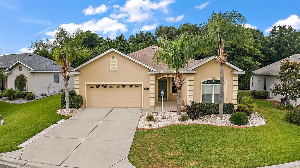 single story home with a garage and a front lawn