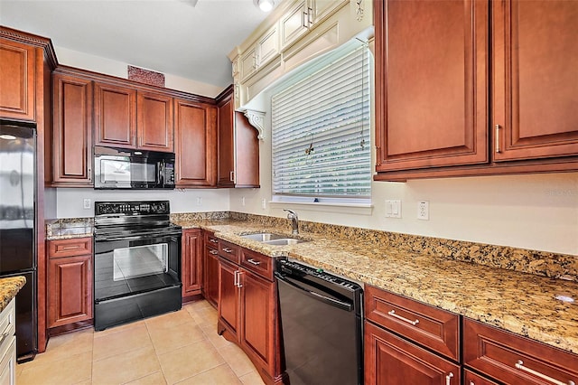 kitchen with light stone counters, sink, light tile patterned floors, and black appliances