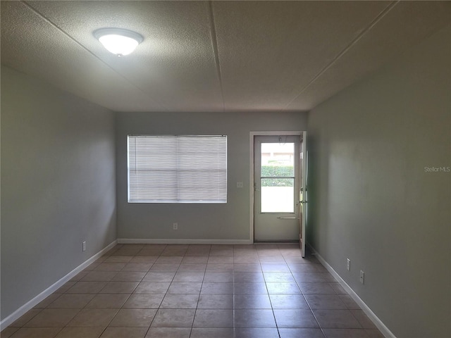 spare room with tile floors and a textured ceiling