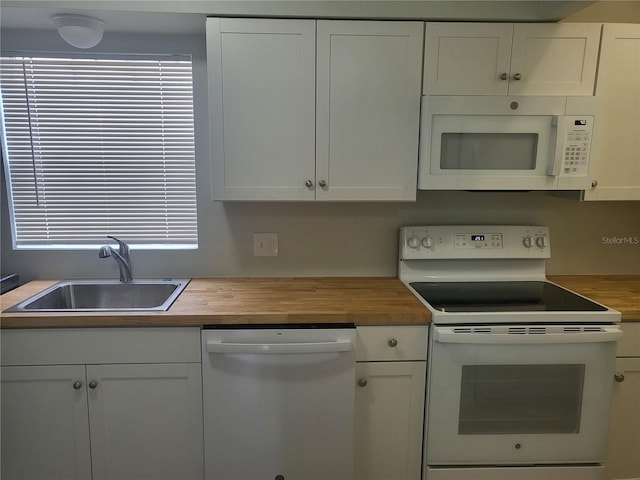 kitchen with white cabinets, white appliances, and butcher block countertops