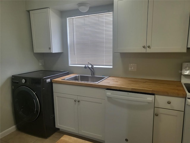 clothes washing area with cabinets, sink, and washer / dryer