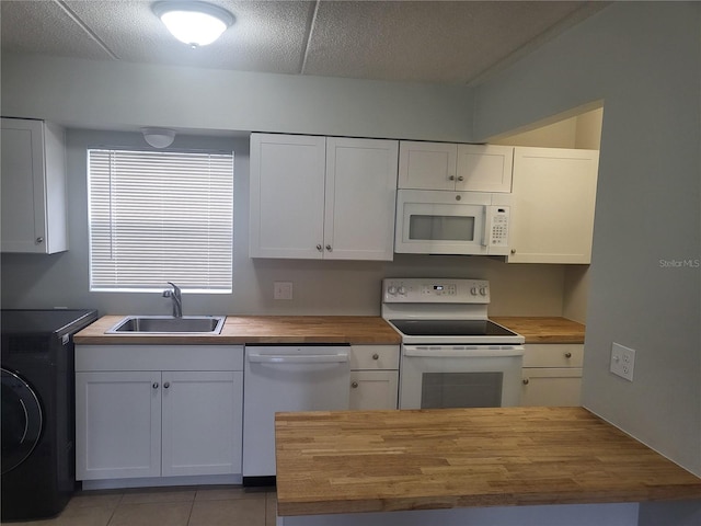 kitchen with washer / dryer, white cabinets, butcher block counters, sink, and white appliances