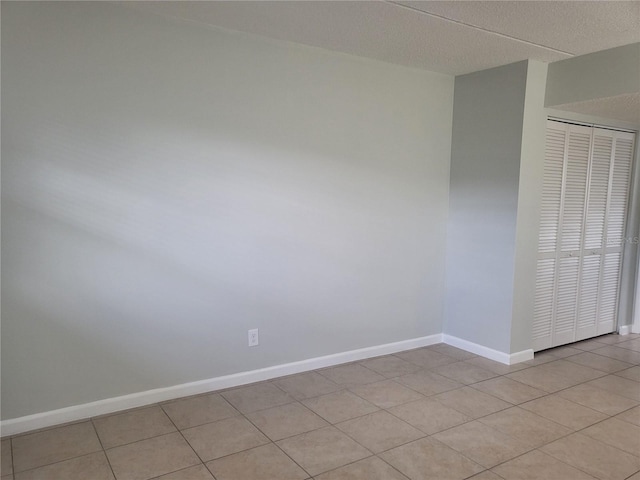 tiled empty room with a textured ceiling