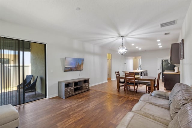 living room with a notable chandelier and dark wood-type flooring