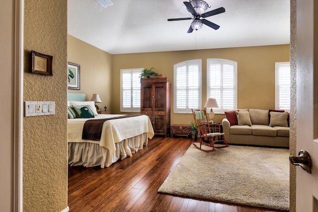 bedroom featuring a textured ceiling, ceiling fan, and dark wood-type flooring