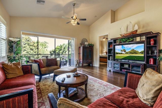 living room featuring a healthy amount of sunlight, lofted ceiling, and dark wood-type flooring