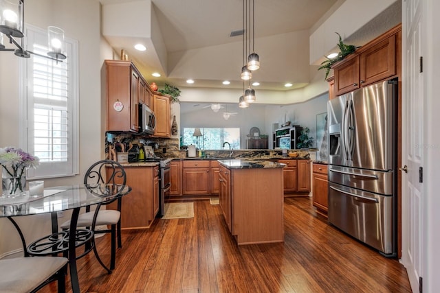 kitchen featuring sink, kitchen peninsula, plenty of natural light, a kitchen island, and appliances with stainless steel finishes