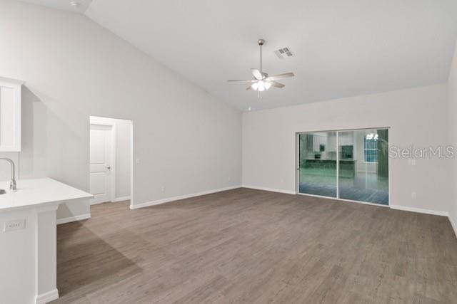 unfurnished living room featuring ceiling fan, dark hardwood / wood-style flooring, and high vaulted ceiling