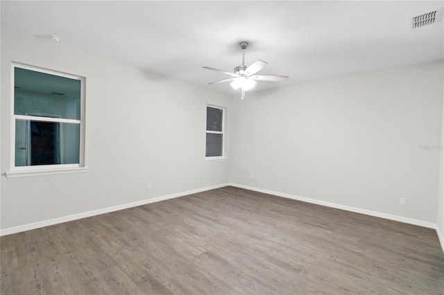 unfurnished room with dark hardwood / wood-style flooring and ceiling fan