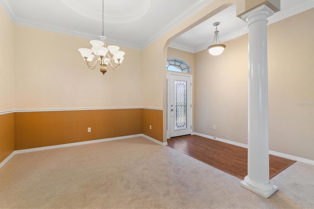 foyer entrance featuring ornamental molding, carpet, a chandelier, and decorative columns