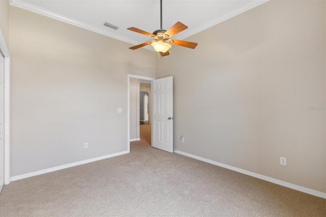 carpeted empty room featuring ceiling fan and crown molding