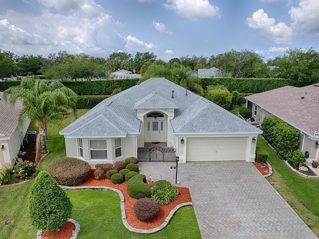 view of front of property with a front yard, a garage, and central AC unit