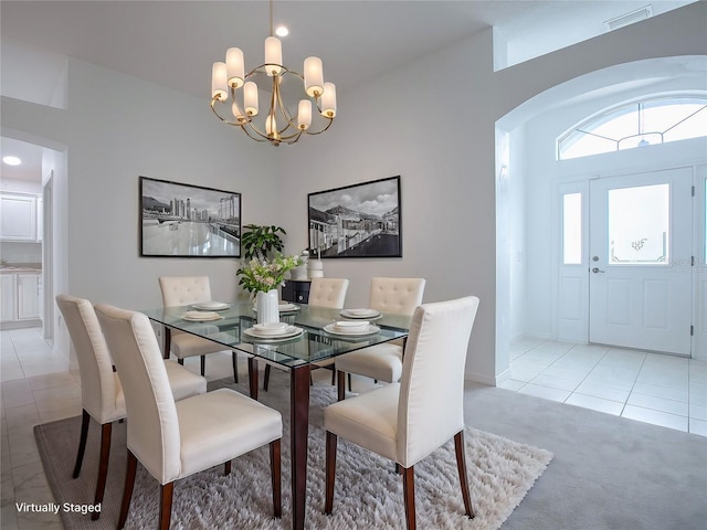 dining area featuring light tile patterned floors and a notable chandelier