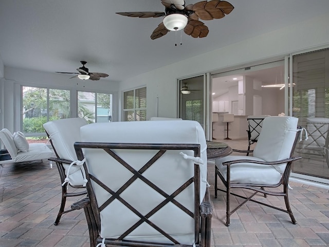 sunroom / solarium featuring ceiling fan