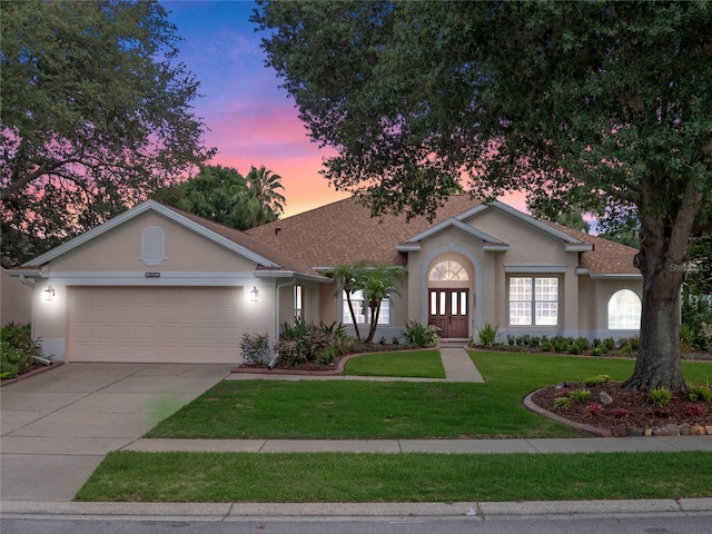 single story home with a yard and a garage