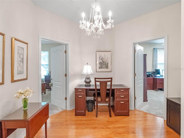 office featuring light hardwood / wood-style floors and an inviting chandelier