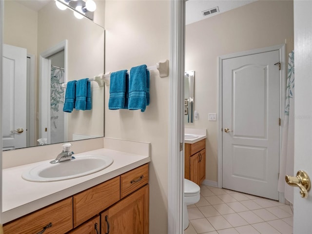 bathroom with tile patterned flooring, vanity, and toilet