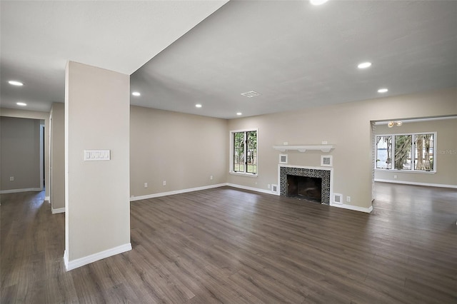 unfurnished living room featuring a fireplace and dark hardwood / wood-style flooring