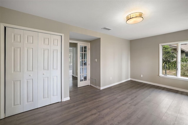 unfurnished bedroom with a closet and dark wood-type flooring