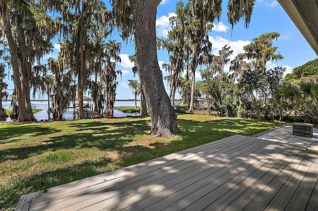 wooden terrace featuring a lawn and a water view