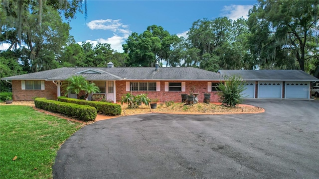 ranch-style house with a garage and a front lawn