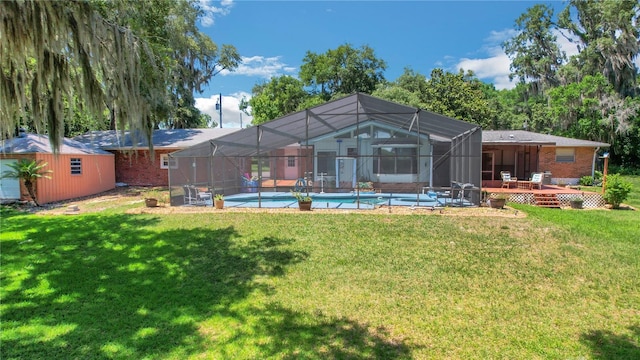 back of house with glass enclosure, a storage shed, and a lawn