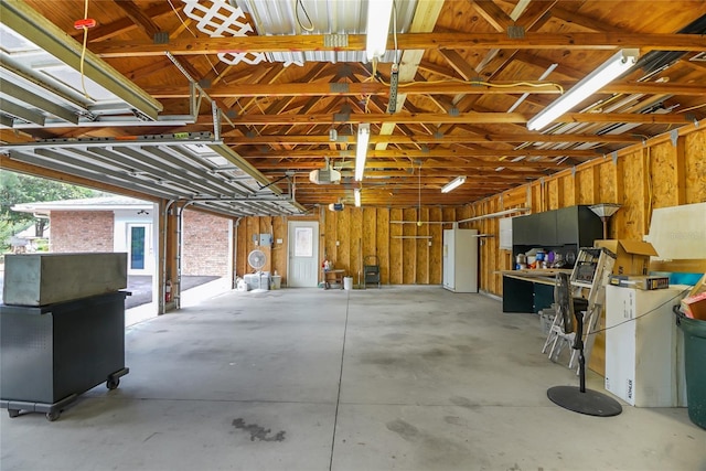 garage with a garage door opener and white refrigerator