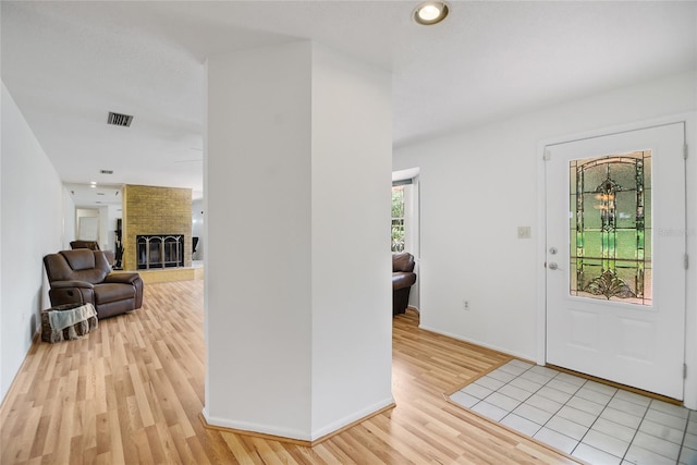 foyer with a fireplace and light hardwood / wood-style flooring