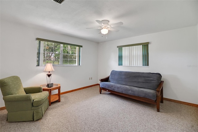 sitting room with ceiling fan, carpet floors, and a textured ceiling