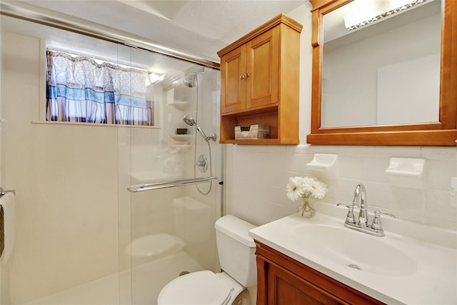 bathroom featuring vanity, toilet, a shower with door, and decorative backsplash