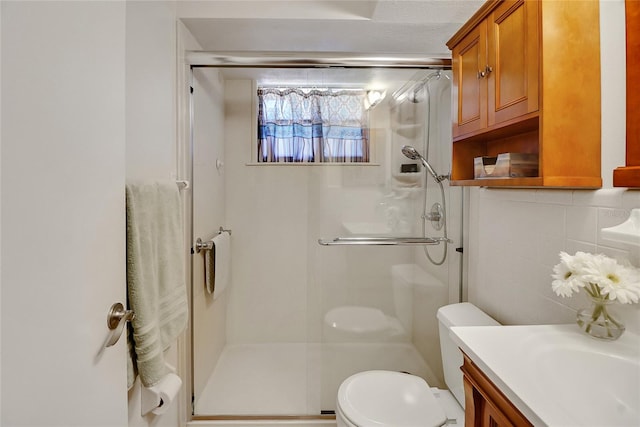 bathroom featuring decorative backsplash, toilet, walk in shower, and vanity