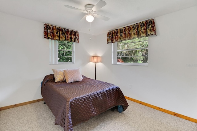 bedroom featuring multiple windows, ceiling fan, and light carpet